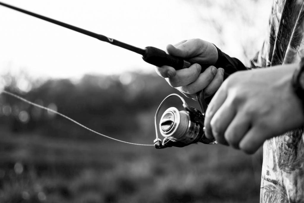 Close up shot on man retrieving fishing line.
