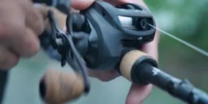 Man fishing with the 13 Fishing Concept A casting reel