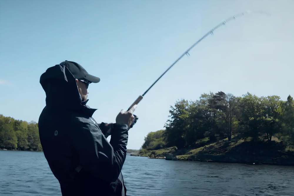 Abu Garcia Revo MGX Spinning Reel with man in the background.