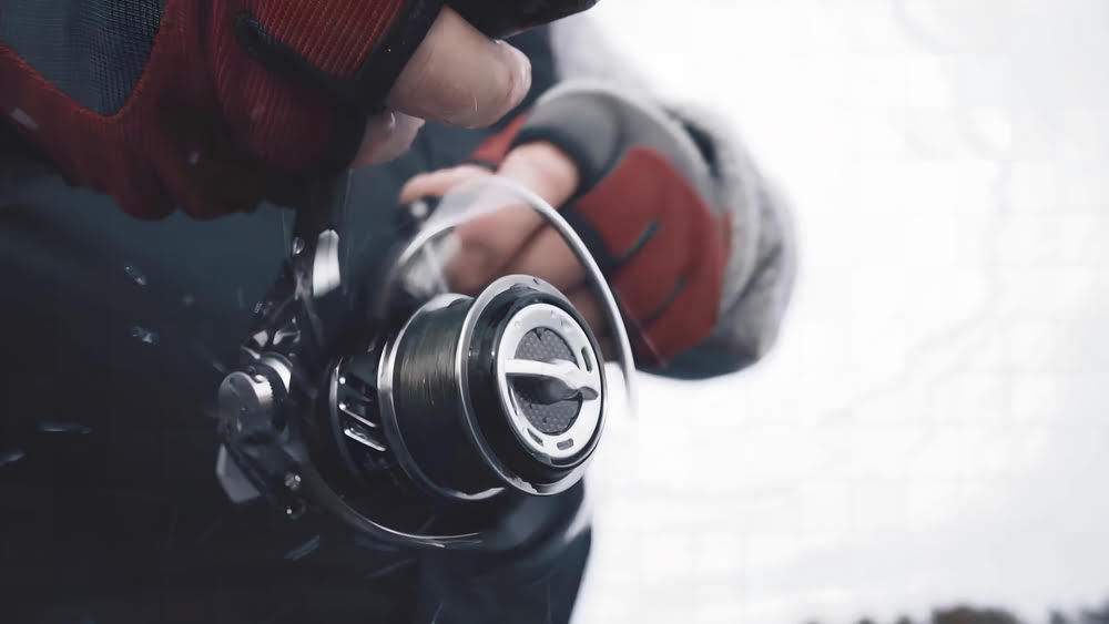 Handsome angler in protective headgear fishing with the Okuma ITX Spinning Reel.