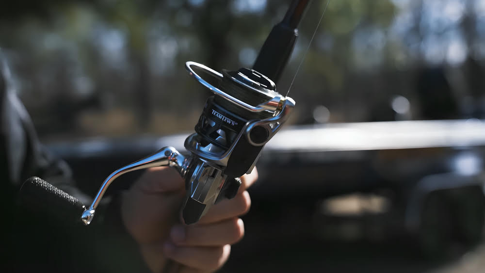 Sporting a Lews HyperMag Spinning Reel for angling.