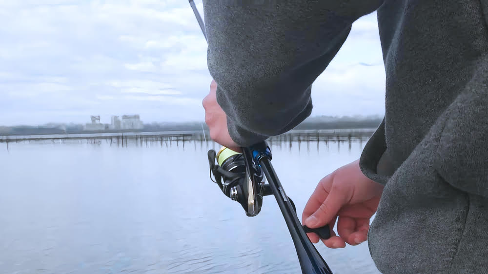 Wading in a body of water with a Shimano Sustain FJ Spinning Reel.