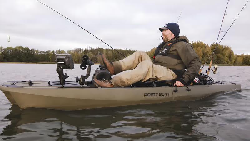 A man sitting in a fishing kayak on a lake