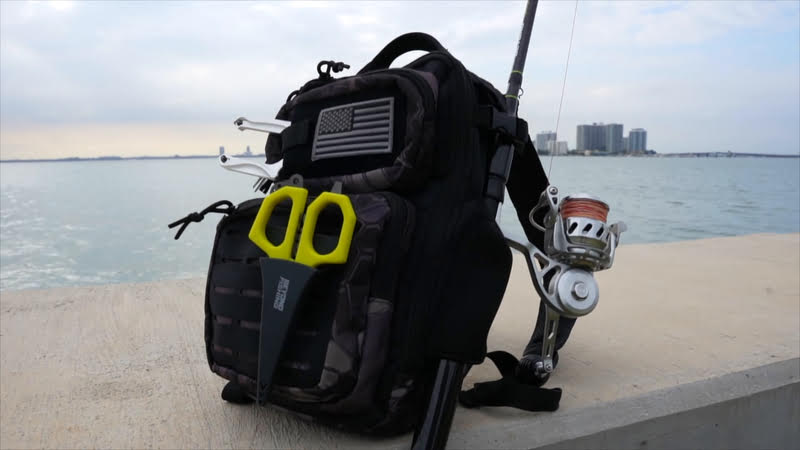 A fishing tackle backpack with a fishing rod and scissors
