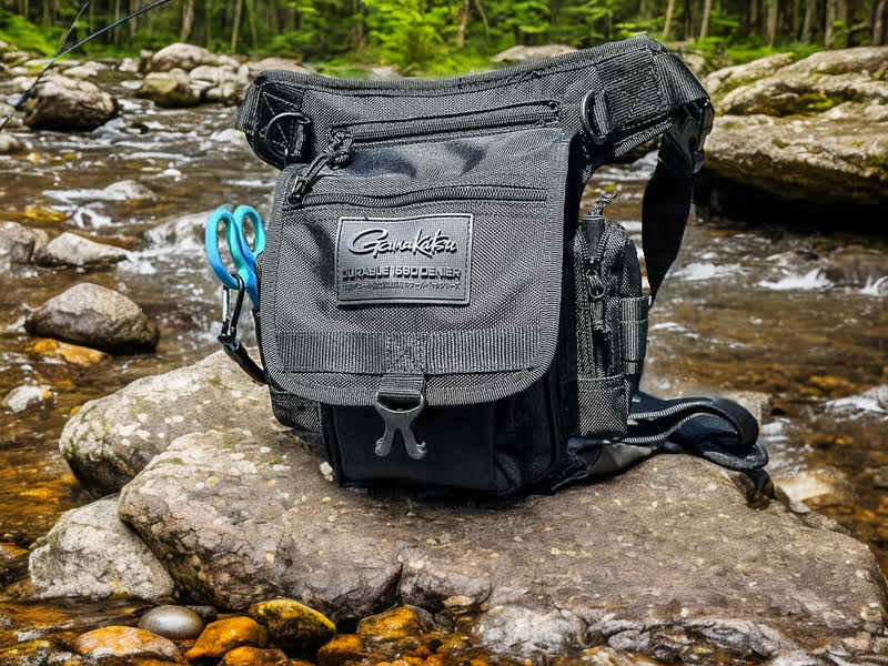 Gamakatsu Shoulder Bag Tackle Storage sitting on a rock in a stream