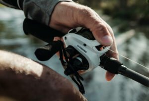 A person holding the 13 Fishing Origin C baitcasting reel