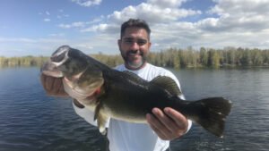 A man holding a large bass fish on a lake
