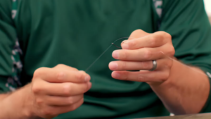 A man rigging a drop shot fishing setup